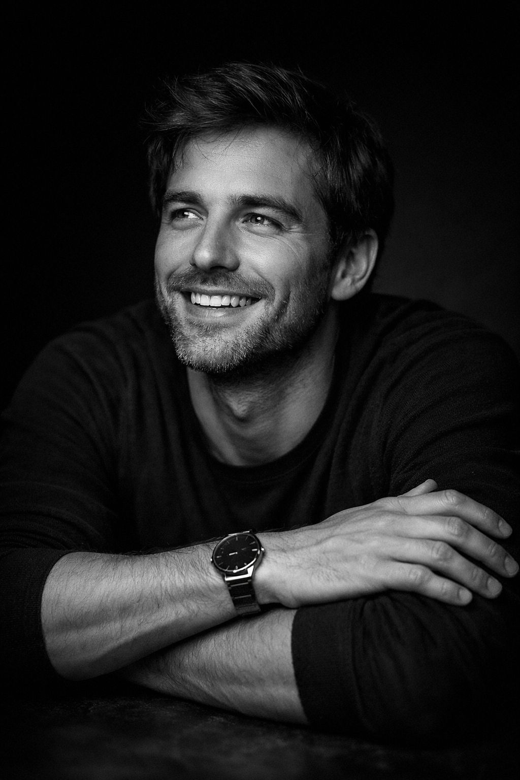 Ultra-realistic cinematic black and white portrait of a smiling young man leaning forward with arms 