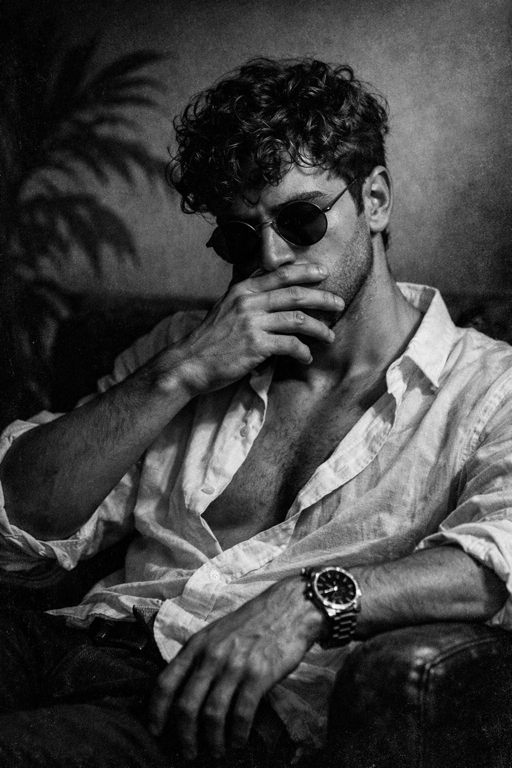 Ultra-realistic black and white portrait of a young man sitting in a relaxed pose, body slightly lea