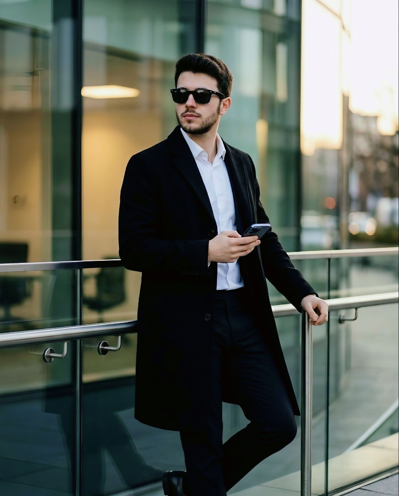 Ultra-realistic cinematic full-body shot of a stylish young man standing outside a modern glass-fron
