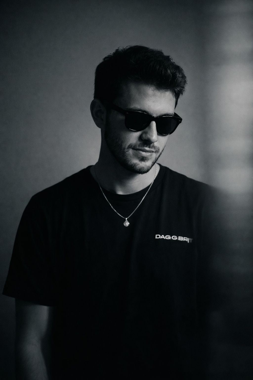 Use exact face from reference (no change). Dark cinematic portrait, black oversized t-shirt, sunglas