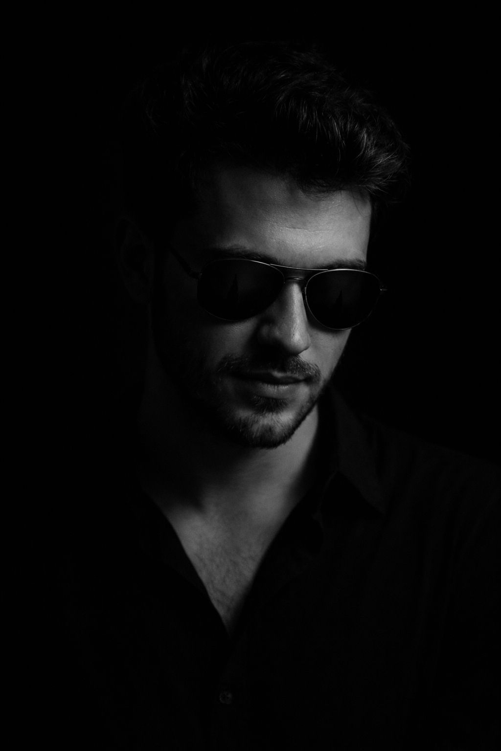 Ultra-realistic 8K cinematic black-and-white portrait of a young man, STRICT pose: head slightly bow
